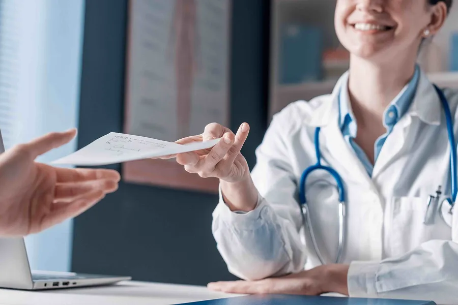 Clinician handing over script to patient